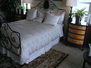 French style wrought iron bed with white linen